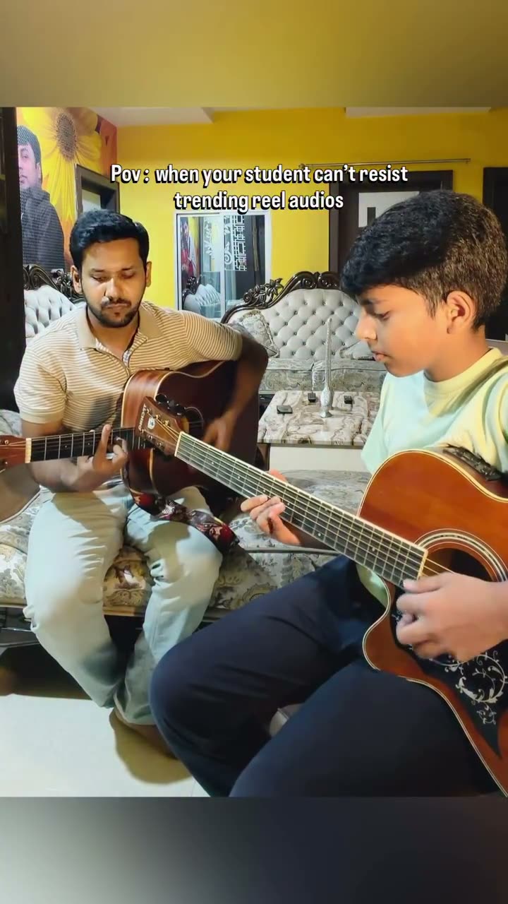 Fahim and a student playing guitar together